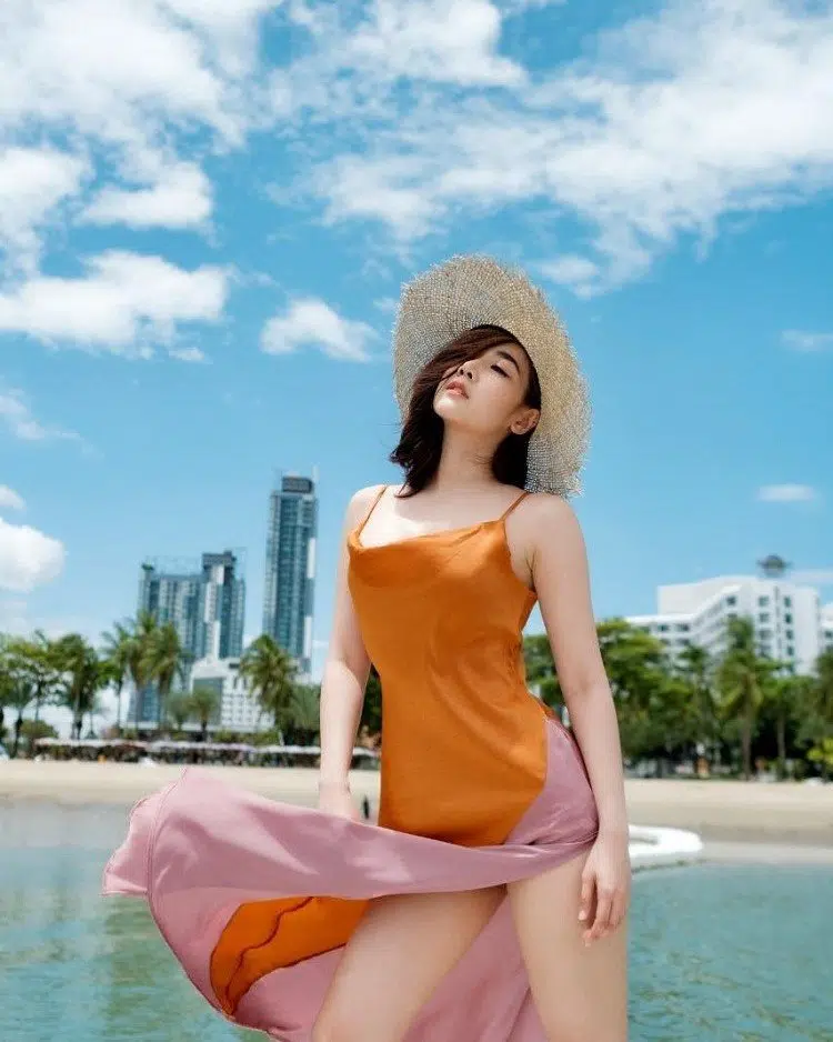 Thai model Manow Bunna in an orange dress on the beach in Thailand
