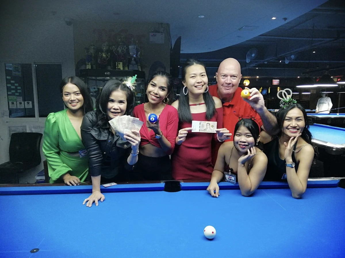 5 thai ladies posing next to a pool table at hustlers pool and sports bar in bangkok