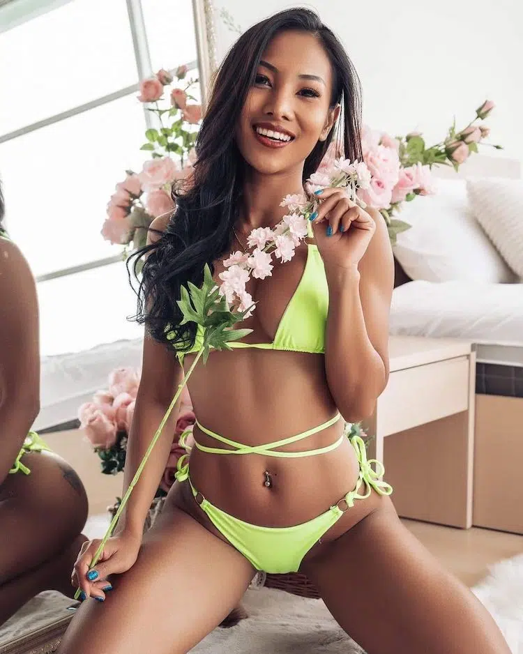 Thai model Juraiwan Kwang wearing a green bikini and holding a flower