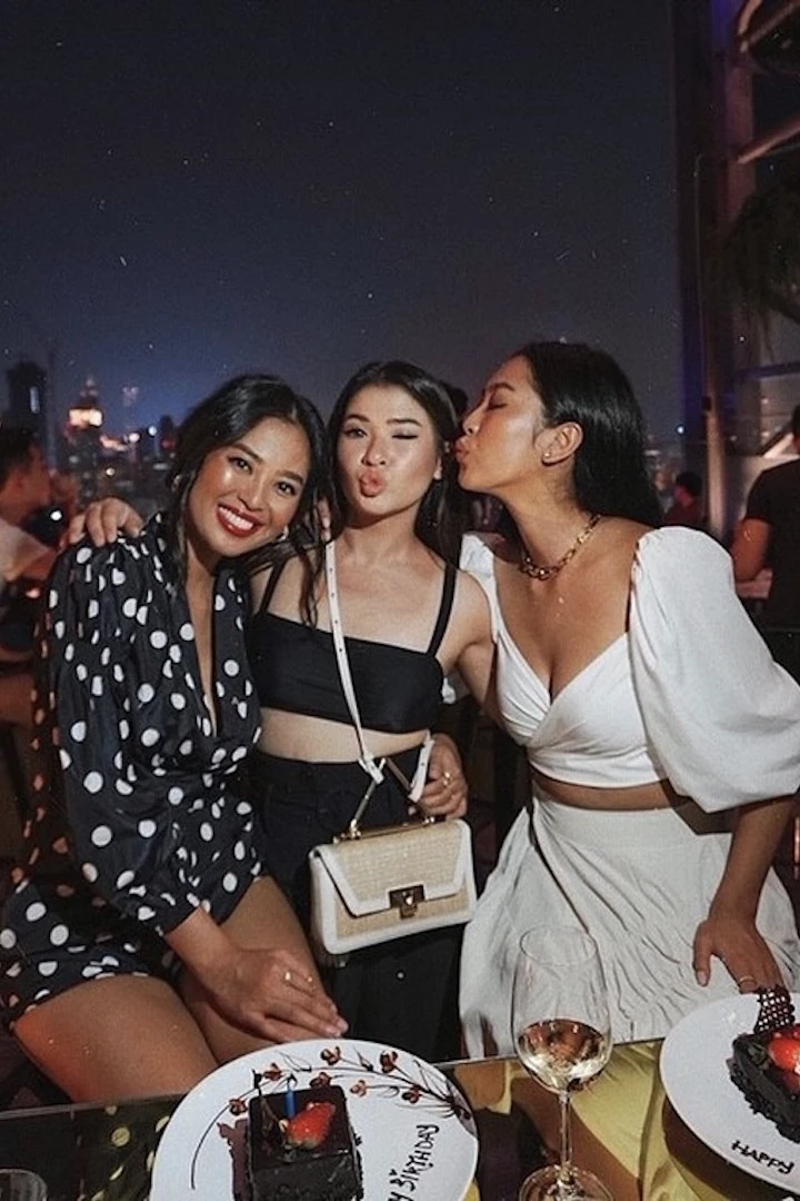 three thai girls posing and partying at hi so rooftop bar at sofitel so a party hotel in bangkok